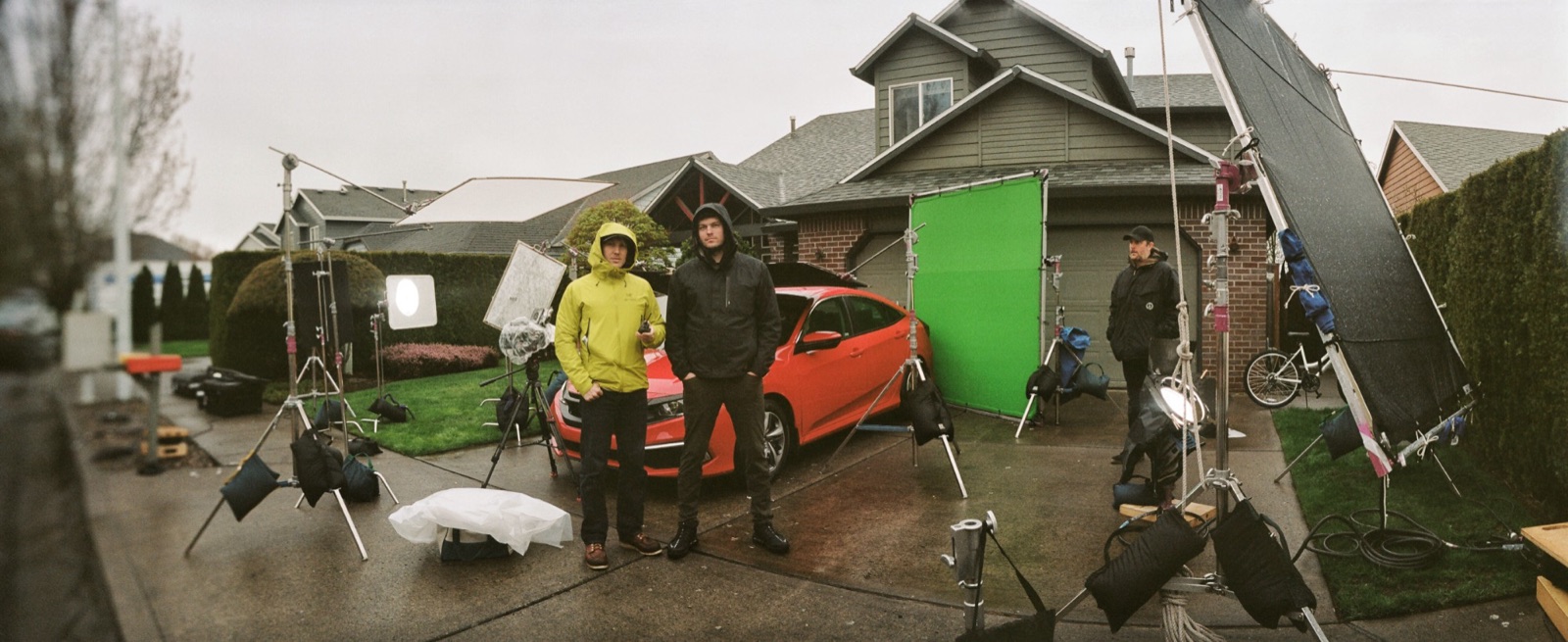 Civic: the driveway setup in the rain, lights, a green screen and overhead frames around the car