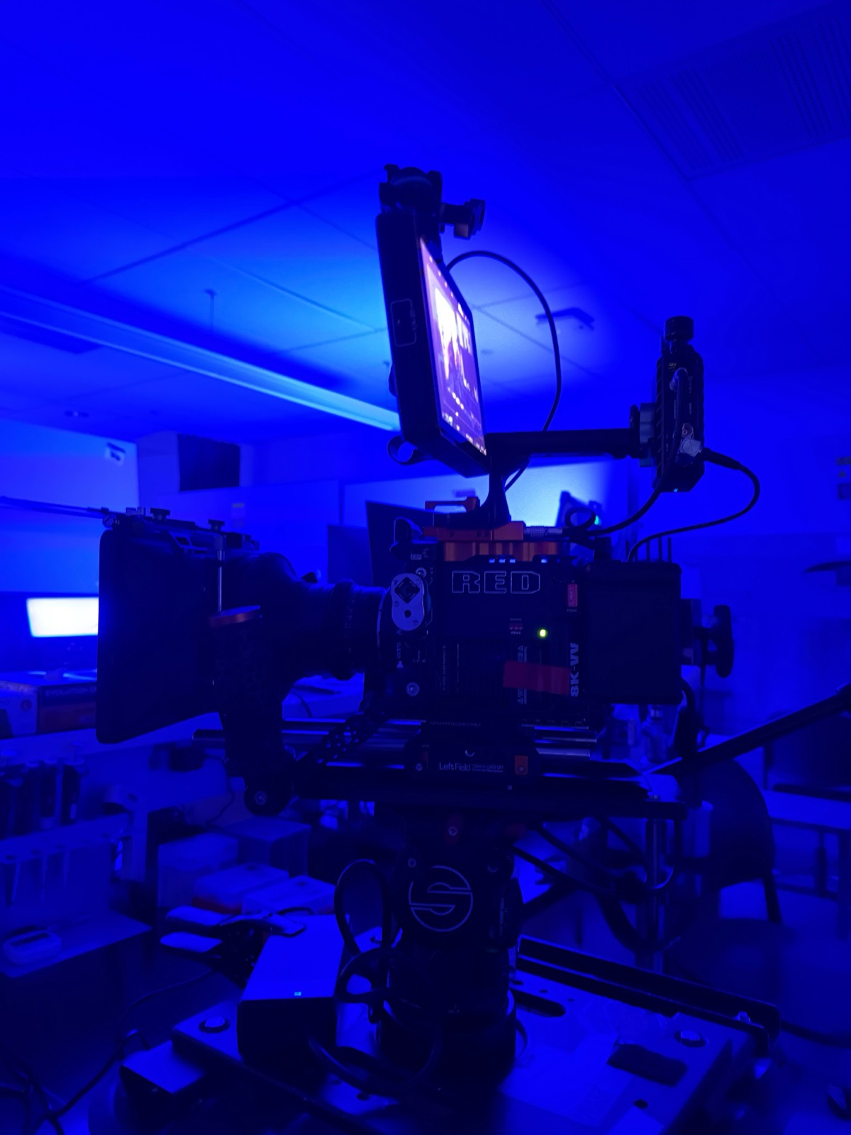 The RED V-Raptor on the dolly in the lab set, room washed in blue
