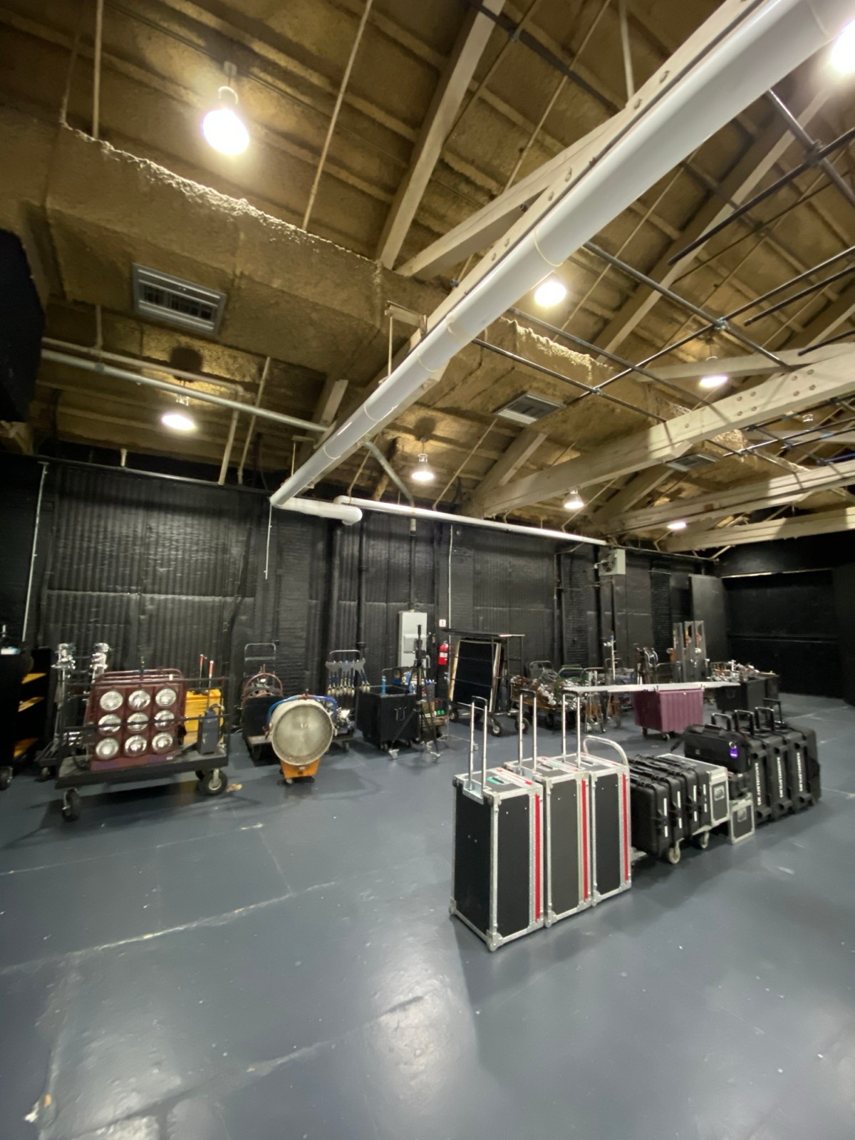 Lighting and grip staged in the black studio before the build, 9-lights and a 20K on carts